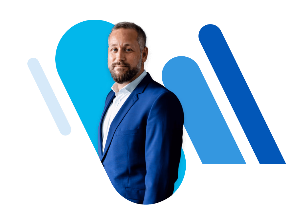 Mann im blauen Blazer, der schräg in die Kamera schaut.